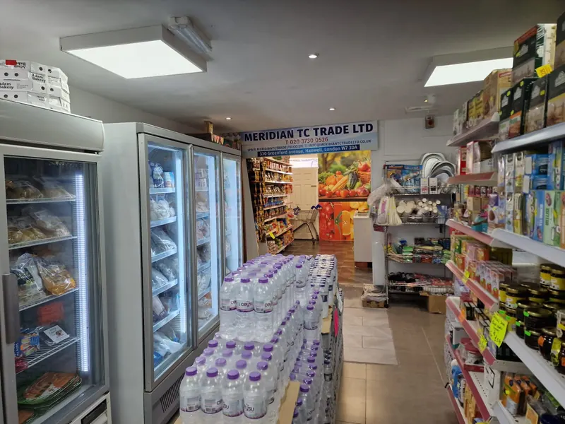 Inside the shop: freezers on the left, stacked cases of bottled water in the middle and shelves of tea on the right.