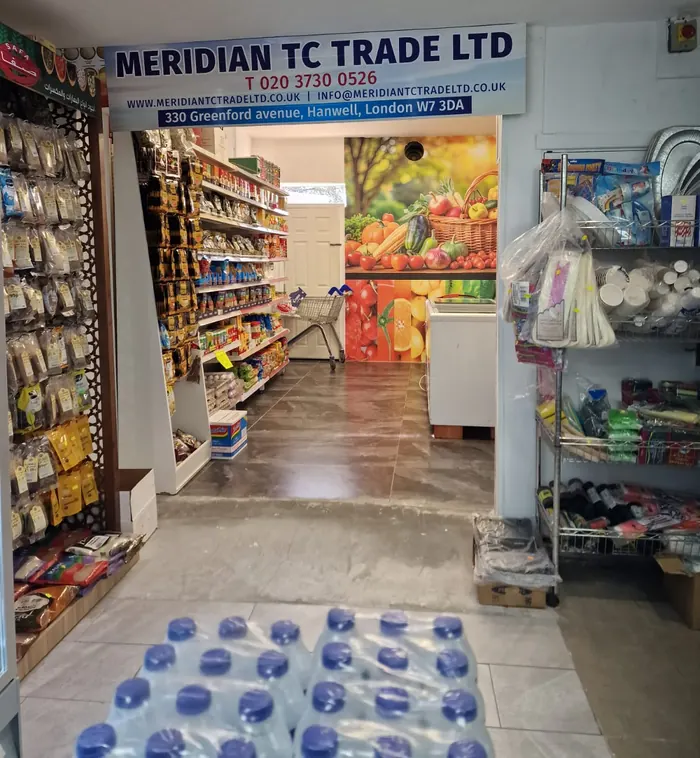 The back room of the shop, with grocery shelves and a fruit and vegetable mural on the wall.